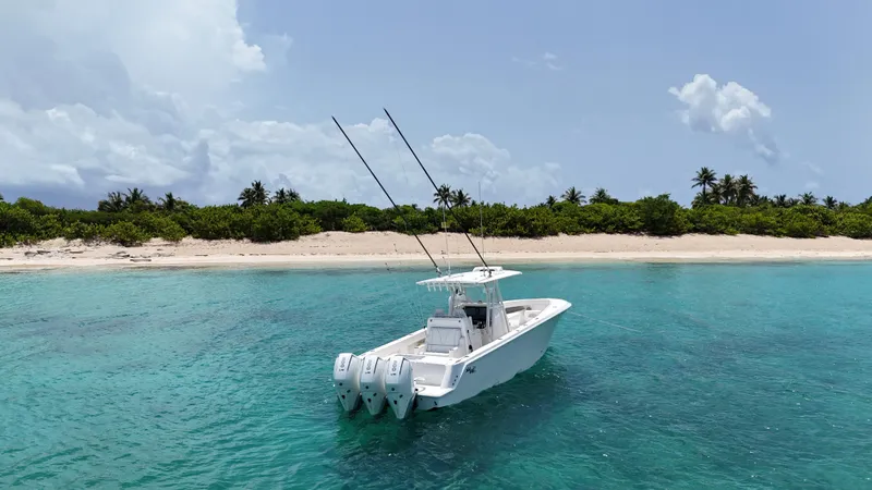  Yacht Photos Pics 2024 SeaVee 340Z boat in clear turquoise water near a tropical beach.
