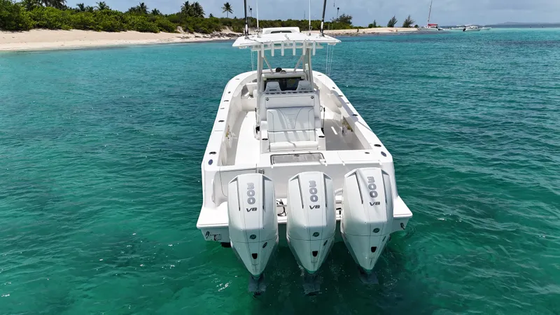  Yacht Photos Pics 2024 SeaVee 340Z boat with triple engines in clear turquoise water near a sandy beach.