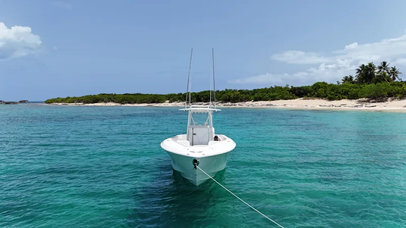  Yacht Photos Pics 2024 SeaVee 340Z boat anchored in clear turquoise water near a sandy beach.