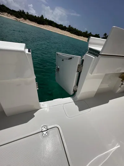  Yacht Photos Pics 2024 SeaVee 340Z boat with open side door, overlooking turquoise water and sandy beach.