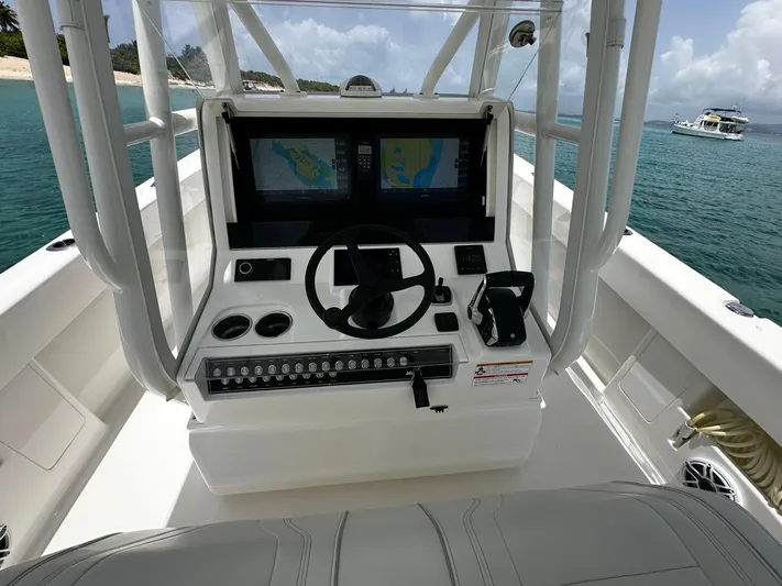  Yacht Photos Pics 2024 SeaVee 340Z boat console with dual screens and steering wheel, docked near a tropical beach.