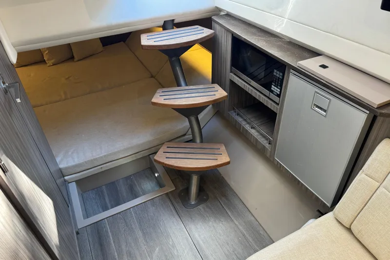 C3 Yacht Photos Pics Interior of 2022 Sea Ray SLX 400 Outboard with wooden steps, bed, and kitchenette.