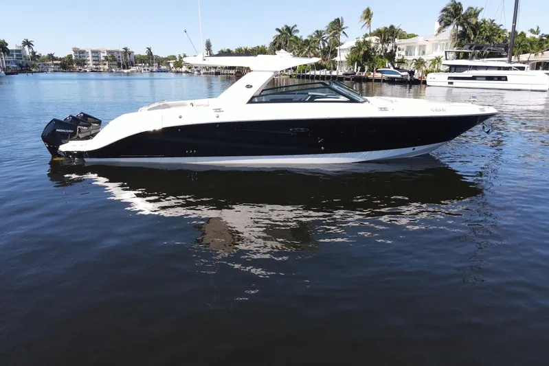 C3 Yacht Photos Pics 2022 Sea Ray SLX 400 Outboard boat on calm water, surrounded by palm trees.