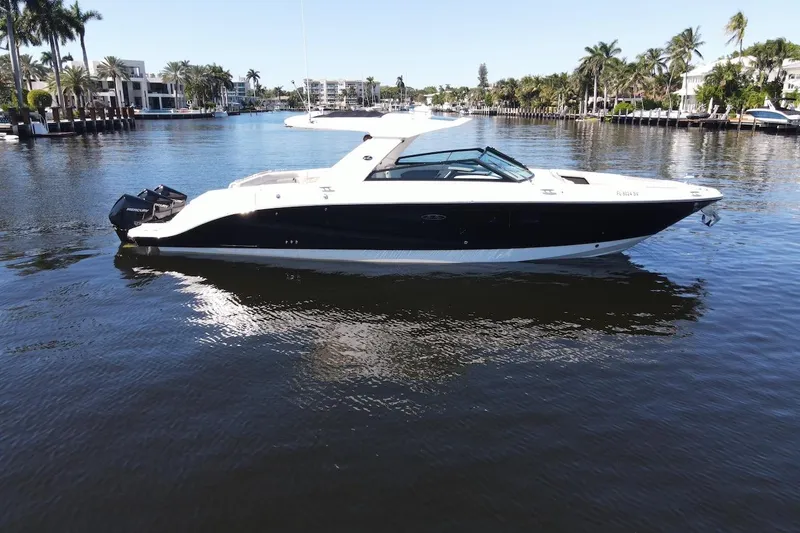C3 Yacht Photos Pics 2022 Sea Ray SLX 400 Outboard boat on a calm waterway, surrounded by palm trees.