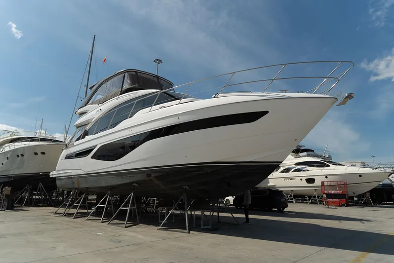  Yacht Photos Pics 2024 Princess F55 yacht on display, elevated on stands, under a clear blue sky.