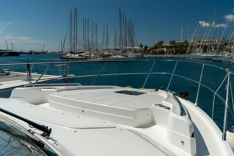 Yacht Photos Pics 2024 Princess F55 yacht docked in a marina with sailboats and clear blue sky.