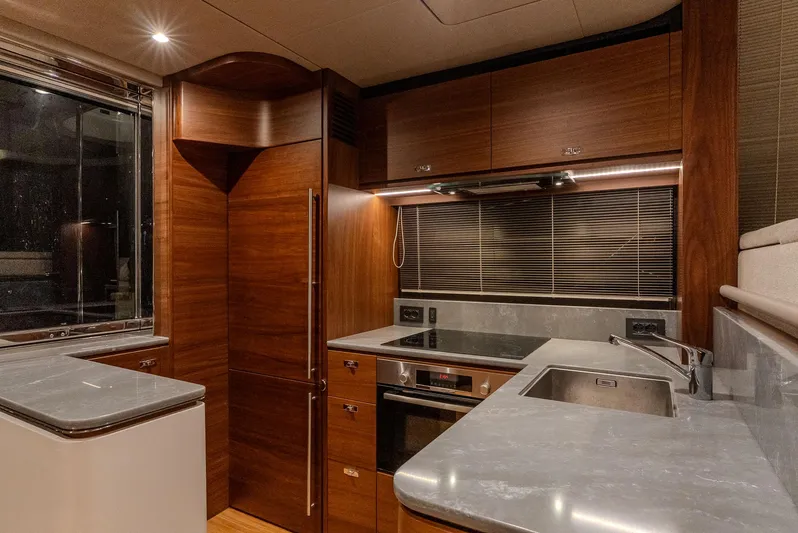  Yacht Photos Pics Luxurious kitchen interior of 2024 Princess F55 yacht with modern appliances and wood finish.