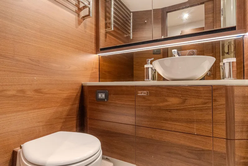  Yacht Photos Pics Luxurious bathroom in 2024 Princess F55 yacht with wooden cabinetry and modern fixtures.