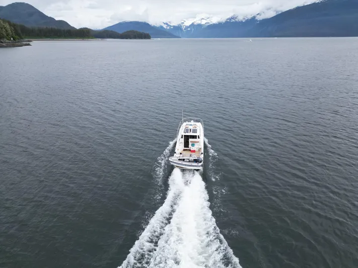  Yacht Photos Pics Aspen C100 boat cruising on a scenic lake with mountainous backdrop, 2026 model.