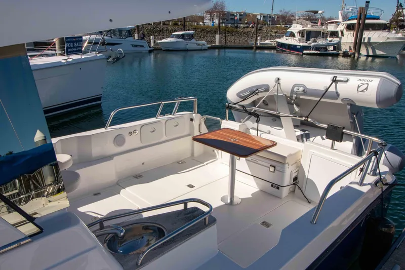  Yacht Photos Pics Aspen C100 2026 boat deck with seating and table, docked in marina.