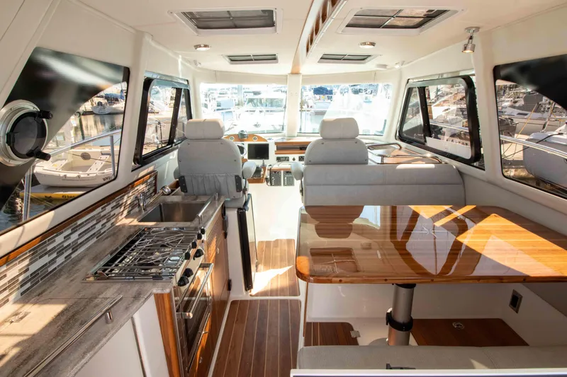  Yacht Photos Pics Luxurious interior of 2026 Aspen C100 yacht with modern kitchen and seating area.