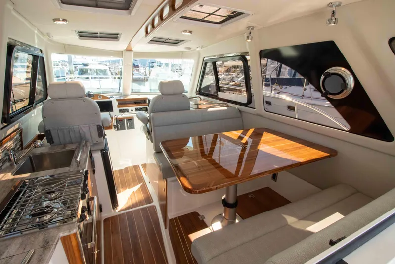  Yacht Photos Pics Luxurious interior of 2026 Aspen C100 boat with modern seating and dining area.