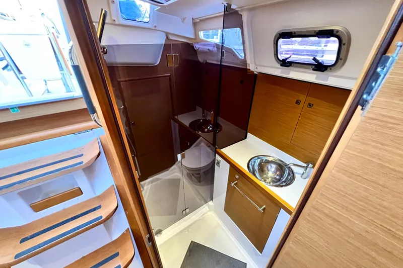  Yacht Photos Pics Interior of 2014 Jeanneau 379 yacht, featuring a compact bathroom with sink and wooden cabinetry.