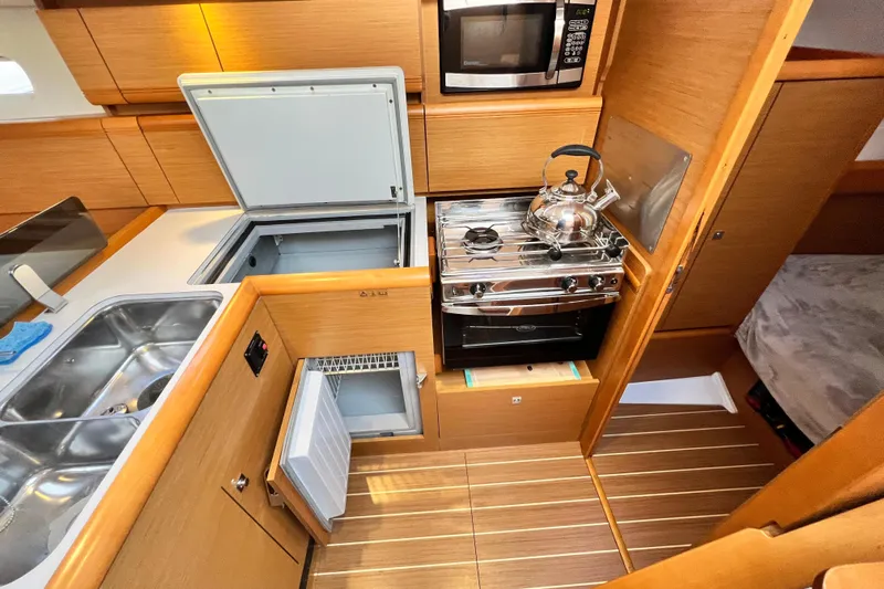  Yacht Photos Pics Modern galley kitchen in 2014 Jeanneau 379 sailboat with stove, sink, and storage.