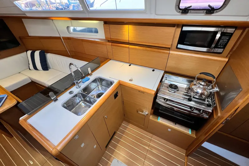  Yacht Photos Pics 2014 Jeanneau 379 yacht interior with modern kitchen, featuring sink, stove, and microwave.