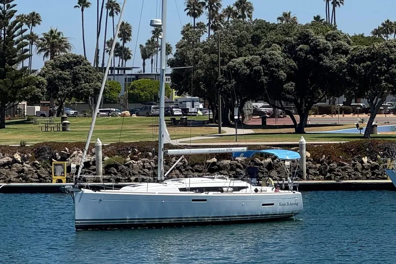  Yacht Photos Pics 2014 Jeanneau 379 sailboat docked in a scenic marina with lush greenery.