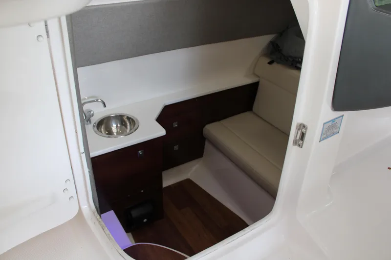  Yacht Photos Pics 2021 Chaparral 280 OSX cabin interior with sink, seating, and storage.