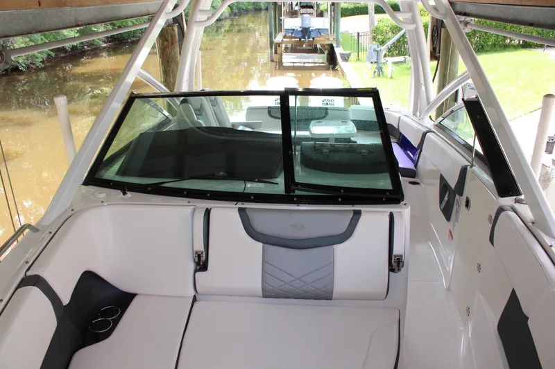  Yacht Photos Pics 2021 Chaparral 280 OSX boat interior with seating and windshield, docked by a river.