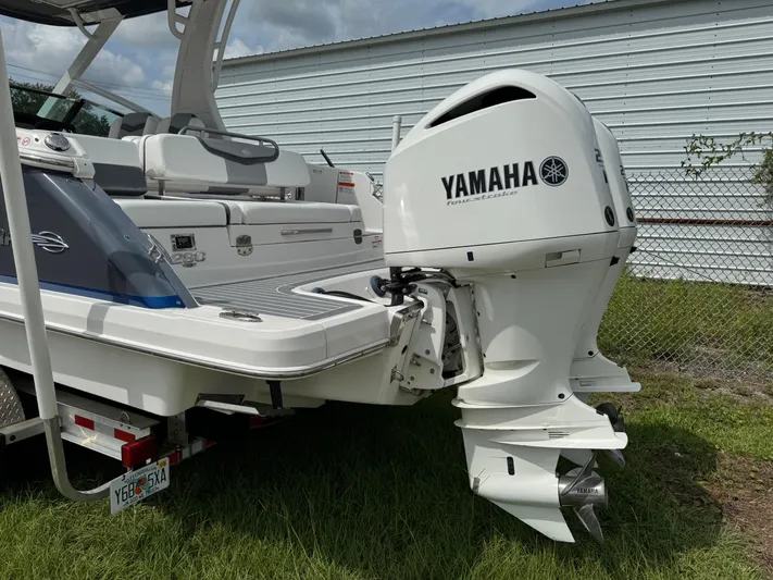  Yacht Photos Pics 2021 Chaparral 280 OSX boat with Yamaha outboard motor, parked on grass.