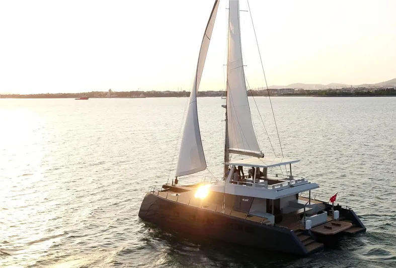 Elif Yacht Photos Pics Luxury Soyaslan CAT63 catamaran sailing at sunset, 2022 model, on calm waters.
