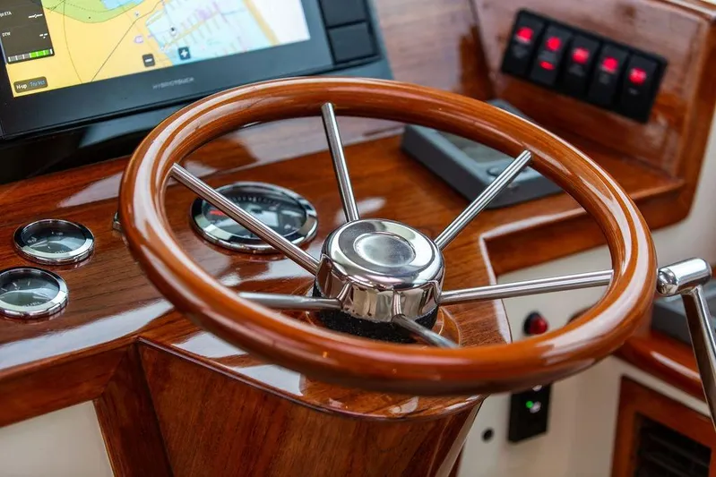 Zuzu Yacht Photos Pics Steering wheel of 2004 Hinckley Picnic Boat EP with navigation controls and gauges.