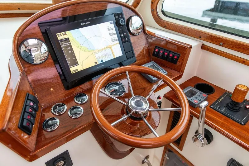 Zuzu Yacht Photos Pics 2004 Hinckley Picnic Boat EP helm with wooden steering wheel and navigation display.