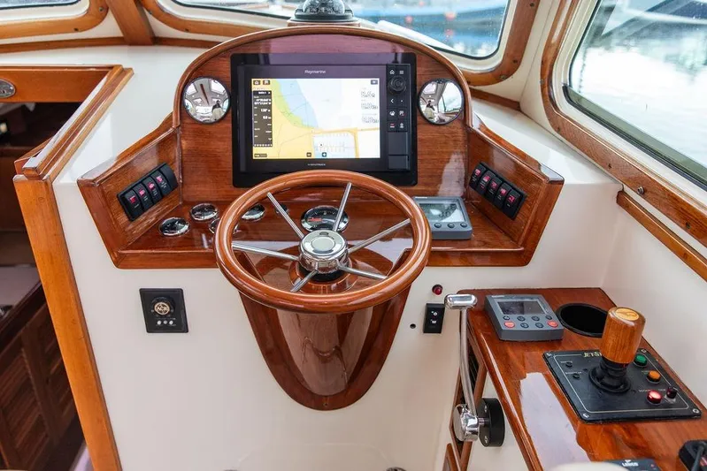 Zuzu Yacht Photos Pics Helm of 2004 Hinckley Picnic Boat EP with wooden steering wheel and navigation controls.