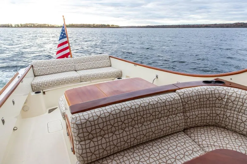 Zuzu Yacht Photos Pics 2004 Hinckley Picnic Boat EP with patterned seating and American flag on open water.