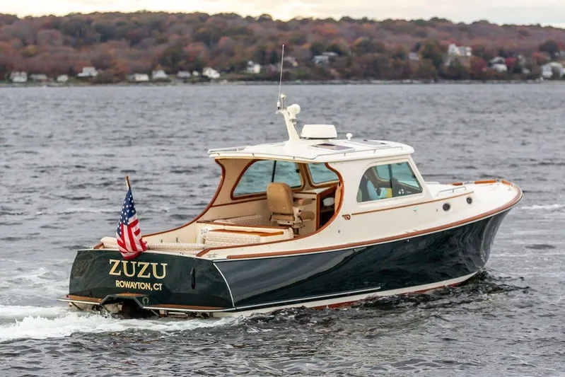 Zuzu Yacht Photos Pics 2004 Hinckley Picnic Boat EP cruising on water with American flag, scenic background.