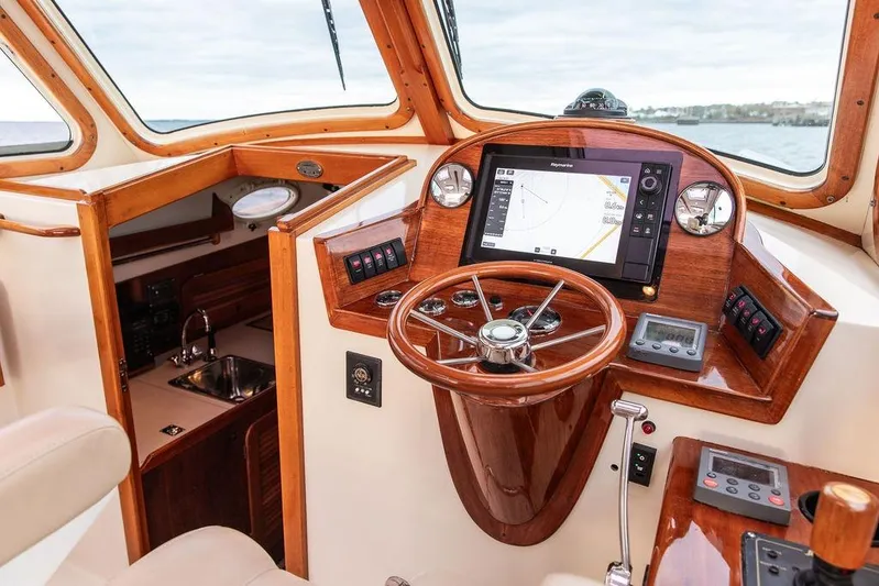 Zuzu Yacht Photos Pics 2004 Hinckley Picnic Boat EP helm with wooden finish and modern navigation system.