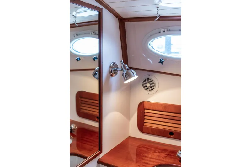 Zuzu Yacht Photos Pics 2004 Hinckley Picnic Boat EP interior with wooden accents and porthole window.