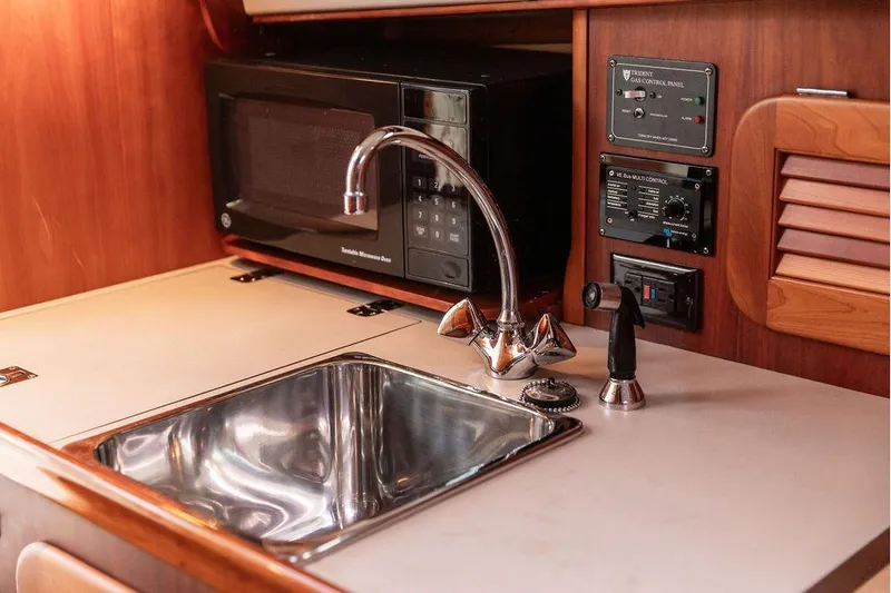 Zuzu Yacht Photos Pics 2004 Hinckley Picnic Boat EP galley with sink, microwave, and control panels.