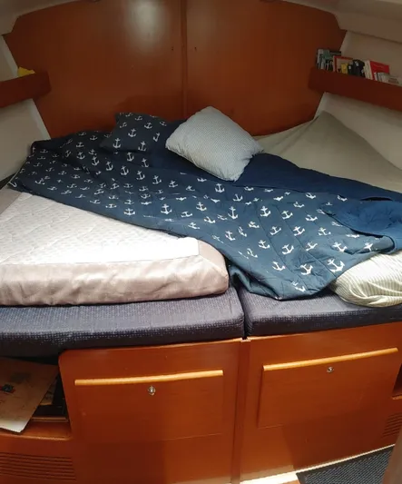 Blue Nomade Yacht Photos Pics Cozy cabin interior of 2006 Beneteau Cyclades 50.4 sailboat with anchor-themed bedding.