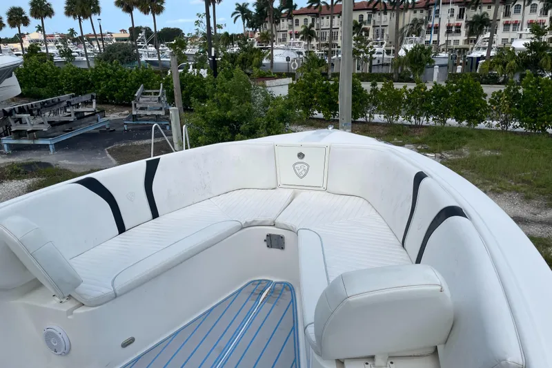 Intensity 2 Yacht Photos Pics 2015 Century 2901 Center Console boat with white seating, docked near palm trees and buildings.