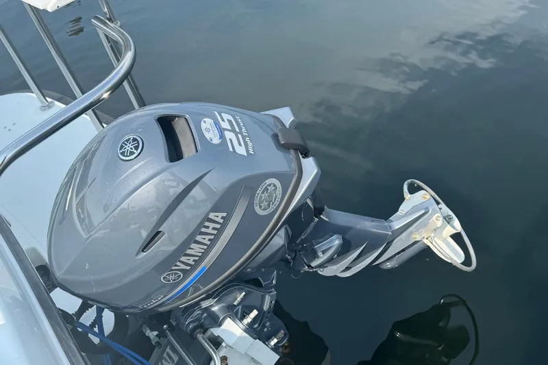  Yacht Photos Pics Yamaha 25HP outboard motor on 2017 Ocean Sport Roamer boat, docked on calm water.
