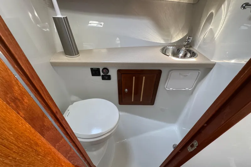  Yacht Photos Pics Compact bathroom in 2017 Ocean Sport Roamer boat with toilet and sink.