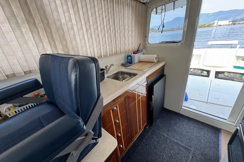  Yacht Photos Pics Interior of a 2017 Ocean Sport Roamer boat with kitchenette and seating.