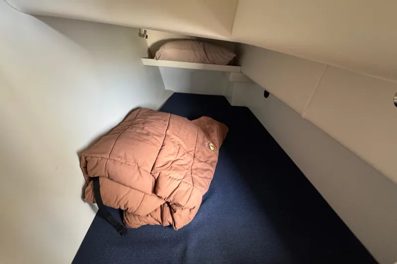  Yacht Photos Pics Cozy cabin interior of 2017 Ocean Sport Roamer with folded brown bedding.