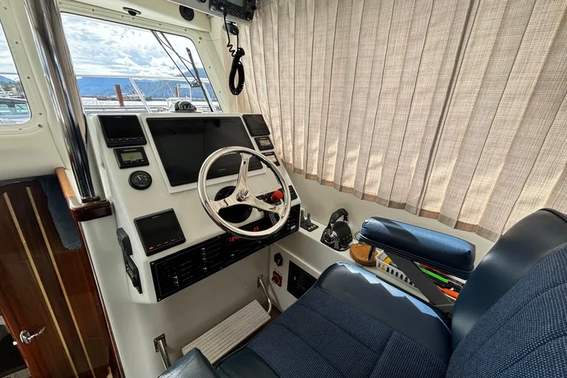  Yacht Photos Pics 2017 Ocean Sport Roamer helm with steering wheel, navigation screens, and comfortable seating.