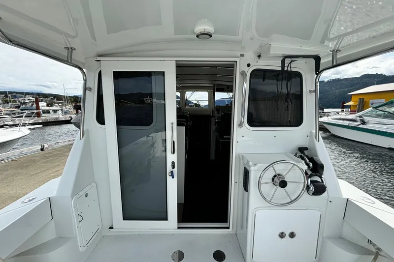  Yacht Photos Pics 2017 Ocean Sport Roamer boat interior with sliding door and steering wheel at marina.