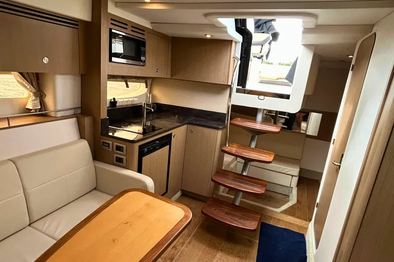  Yacht Photos Pics Interior of 2017 Sea Ray Sundancer 350 Coupe with modern kitchen and wooden stairs.