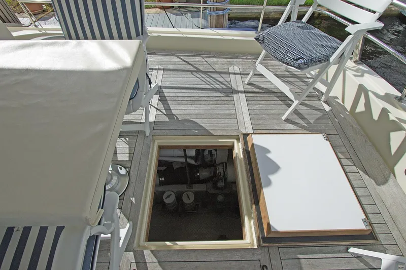 Just Right Yacht Photos Pics 2004 Dettling Express Cruiser deck with open hatch, striped chairs, and wooden flooring.