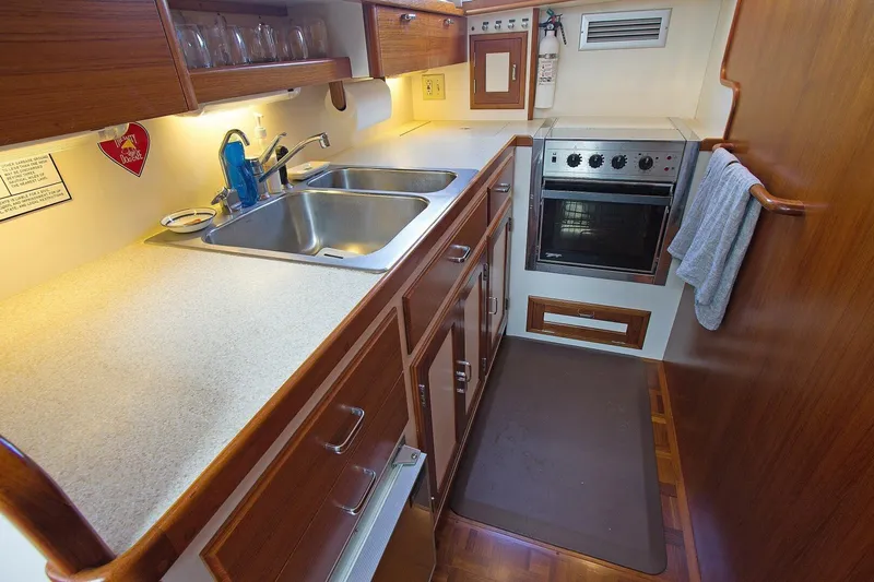 Just Right Yacht Photos Pics 2004 Dettling Express Cruiser kitchen with sink, oven, and wooden cabinetry.