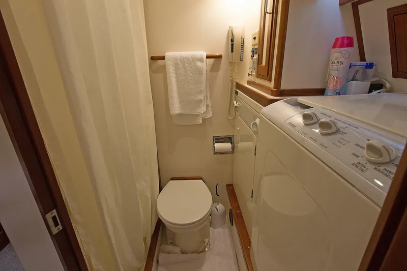 Just Right Yacht Photos Pics 2004 Dettling Express Cruiser bathroom with toilet, washing machine, and towel rack.