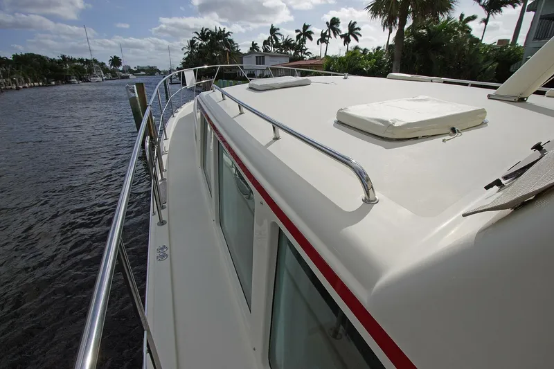 Just Right Yacht Photos Pics 2004 Dettling Express Cruiser on a scenic waterway, surrounded by lush palm trees.