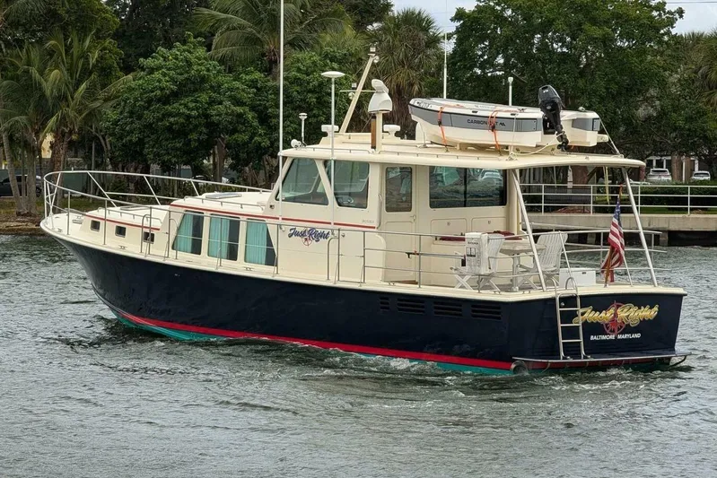 Just Right Yacht Photos Pics 2004 Dettling Express Cruiser on water, featuring sleek design and American flag.