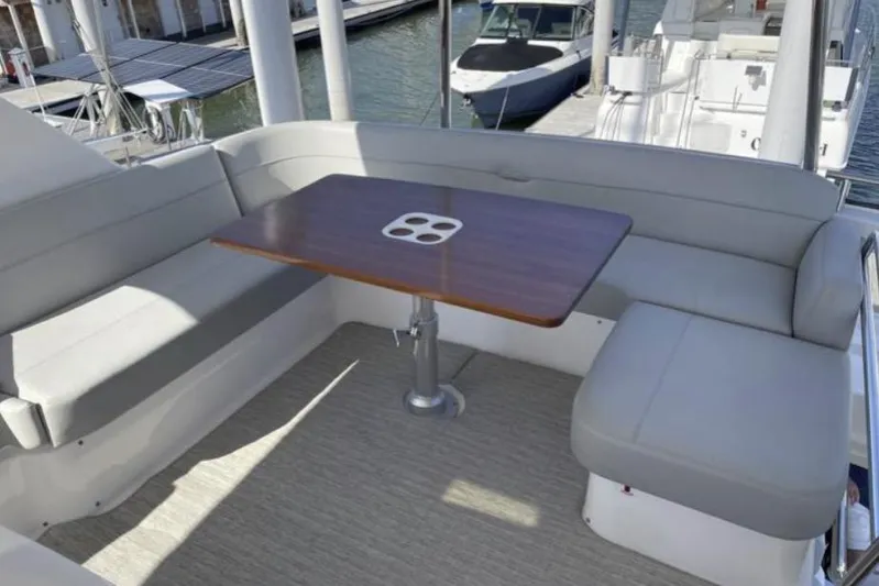 Mi Dia Yacht Photos Pics 2019 Tiara Yachts F53 Flybridge seating area with wooden table and gray cushions.