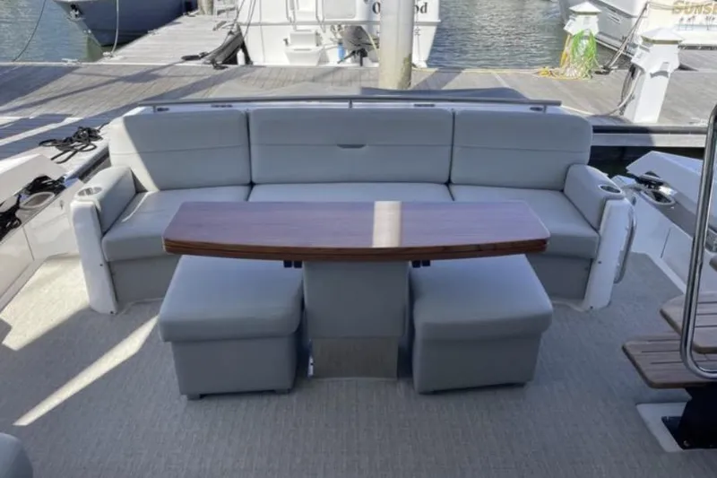 Mi Dia Yacht Photos Pics 2019 Tiara Yachts F53 Flybridge, elegant seating area with wooden table on deck.