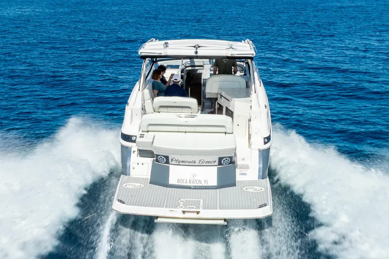 "plymouth Breeze" Yacht Photos Pics 2020 Regal 35 Sport Coupe cruising on open blue water, rear view.