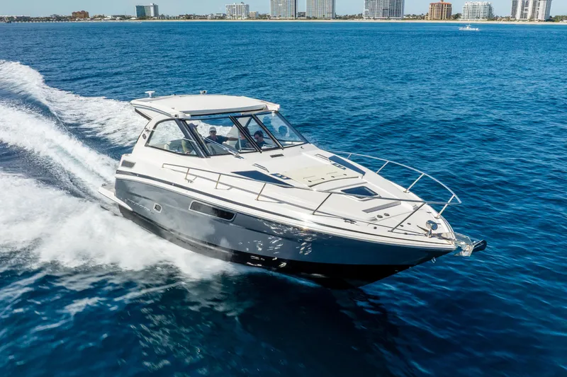 "plymouth Breeze" Yacht Photos Pics 2020 Regal 35 Sport Coupe cruising on open water near city skyline.